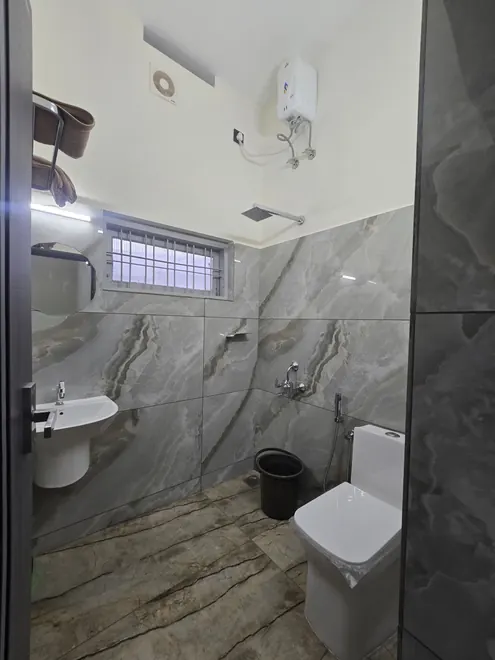 Bright tiled bathroom with washbasin and toilet at Grey Oasis Homestay