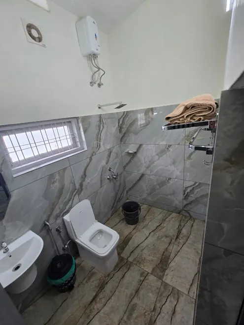 Bathroom at Grey Oasis with a washbasin, toilet and tiled floor