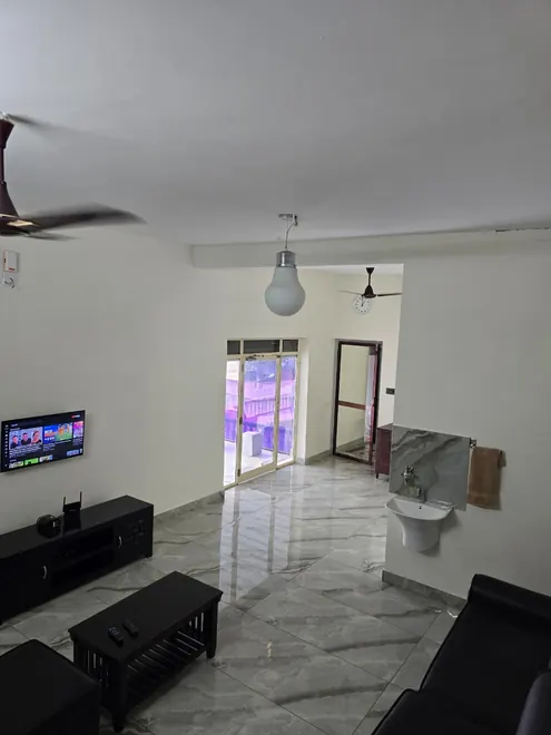 Spacious Grey Oasis living hall with sofas, television and marble-look floor