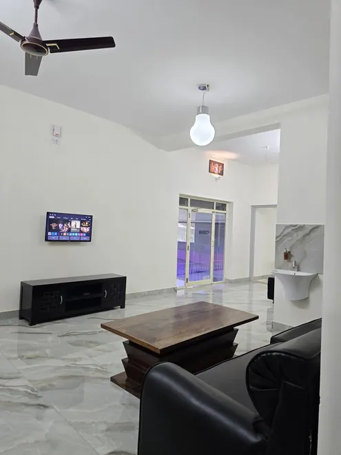 Grey Oasis living room with sofas, TV, coffee table and balcony door